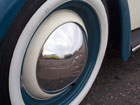 Vans reflected in a Beetle's wheel